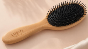 Modelo de escova para cabelo infantil com cabo de madeira e cerdas suaves.